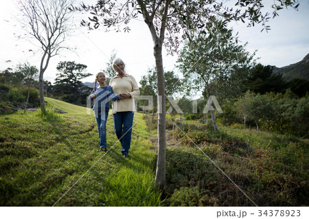 Grandmother and granddaughter walking together in the garden 34378923
