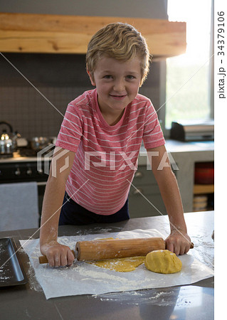 Portrait of smiling boy rolling dough Portrait of smiling boy rolling dough 34379106