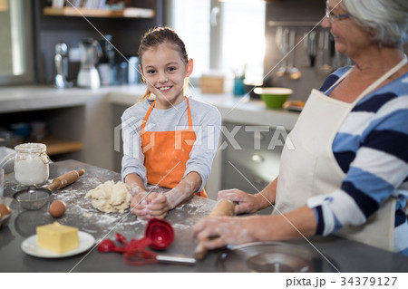 Granddaughter posing while kneading dough in the kitchen 34379127