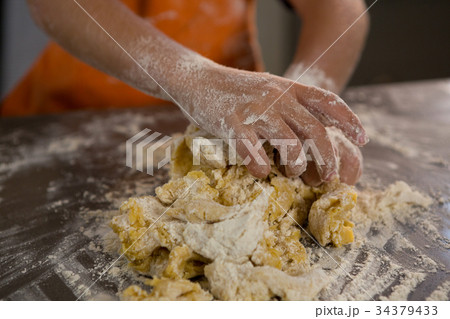 Mid section of boy kneading dough Mid section of boy kneading dough 34379433