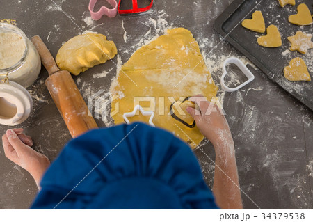 Cropped hands of boy preparing cookies in kitchen 34379538