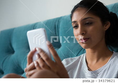 Young woman using phone at home 34379621