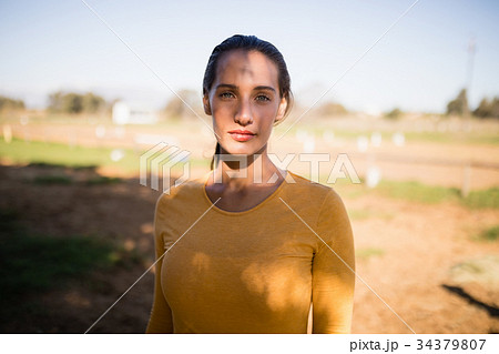 Portrait of serious female jockey standing on field Portrait of serious female jockey standing on field 34379807