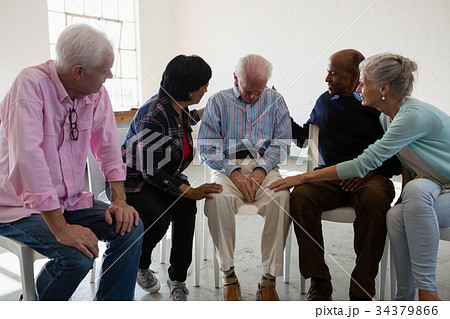 Senior friends consoling male friend Senior friends consoling male friend 34379866