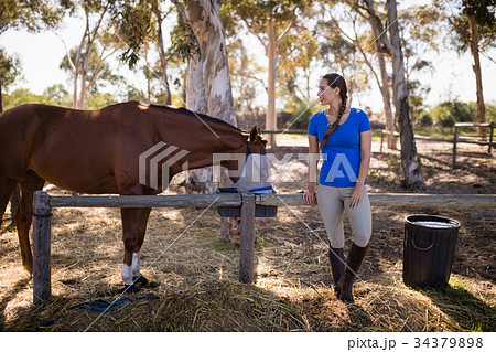 Full length of woman standing by horse Full length of woman standing by horse 34379898