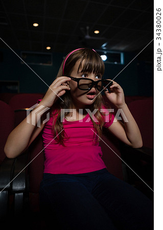Girl using 3D glasses while watching movie Girl using 3D glasses while watching movie 34380026