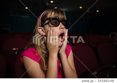 Surprised girl wearing 3D glasses while watching movie Surprised girl wearing 3D glasses while watching movie 34380146
