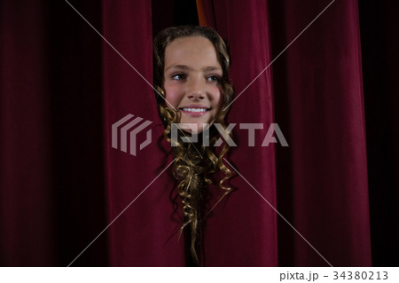 Female artist peeking through the red curtain 34380213
