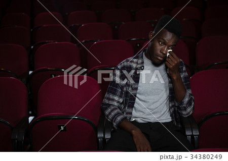 Man getting emotional while watching movie Man getting emotional while watching movie 34380249