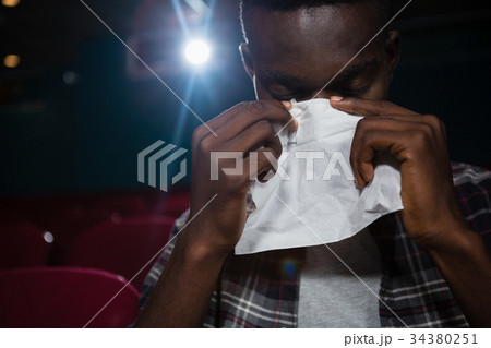 Man getting emotional while watching movie Man getting emotional while watching movie 34380251