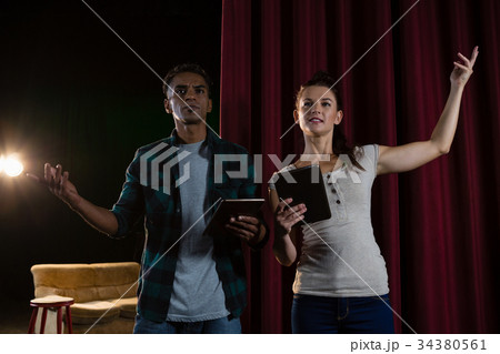 Actors rehearsing on stage while using digital tablet Actors rehearsing on stage while using digital tablet 34380561