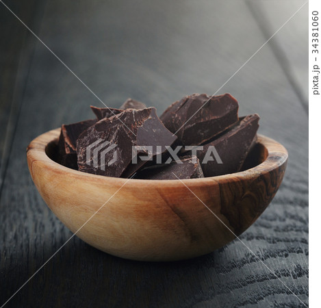 dark chocolate chunks in wooden bowl dark chocolate chunks in wooden bowl 34381060