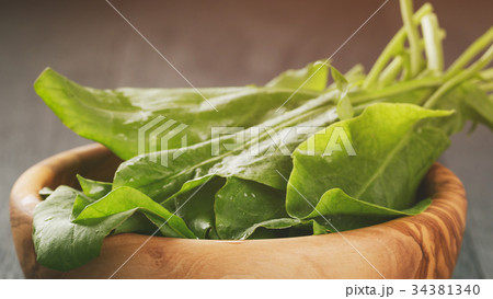 fresh sorrel leaves in olive bowl on oak wood 34381340