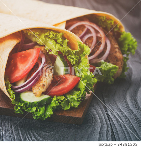 pair of fresh juicy wrap sandwiches with chicken pair of fresh juicy wrap sandwiches with chicken 34381505
