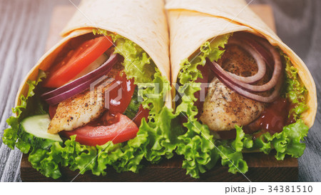 pair of fresh juicy wrap sandwiches with chicken pair of fresh juicy wrap sandwiches with chicken 34381510