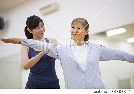 シニア夫婦にヨガを教えるトレーナー シニア夫婦にヨガを教えるトレーナー 34383814