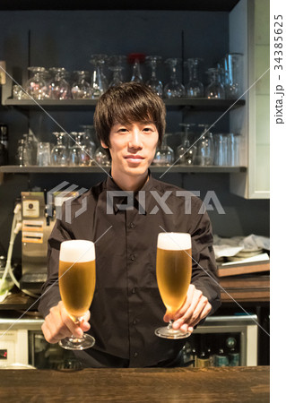 ビールを差し出すバーテンダー 34385625
