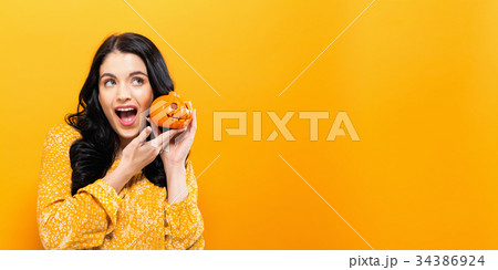 Young woman holding a pumpkin 34386924