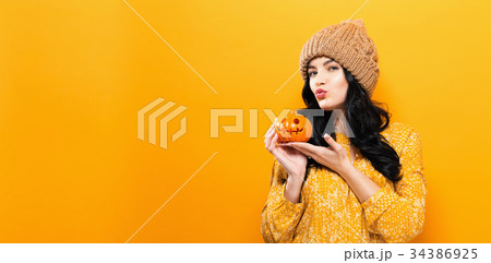 Young woman holding a pumpkin 34386925