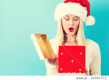 Happy young woman with Christmas present box Happy young woman with Christmas present box 34387771