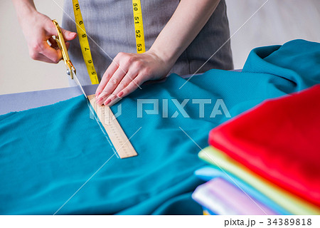 Woman tailor working on a clothing sewing 34389818