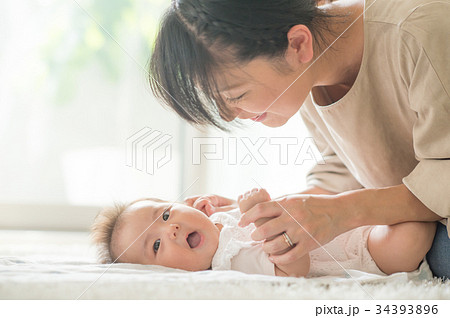 赤ちゃんをあやすママ 笑顔の写真素材