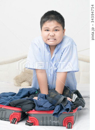 angry boy try to closed suitcase 34394754