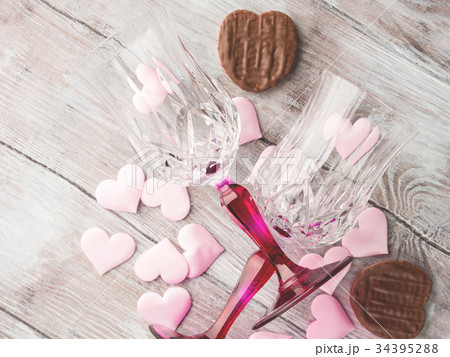Two stemmed glasses with hearts and chocolate 34395288