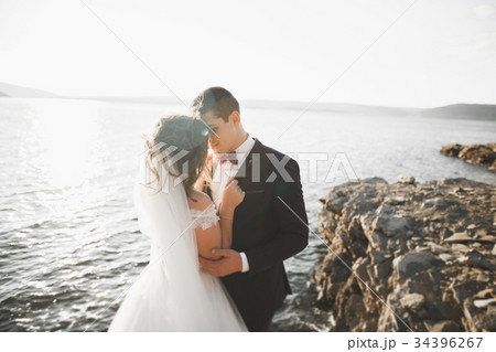 Wedding couple kissing and hugging on rocks near 34396267