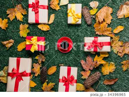 Cup of coffee and autumn yellow leaves with gifts Cup of coffee and autumn yellow leaves with gifts 34396965