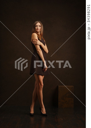 Cute girl in short dress touching her shoulder Cute girl in short dress touching her shoulder 34398291