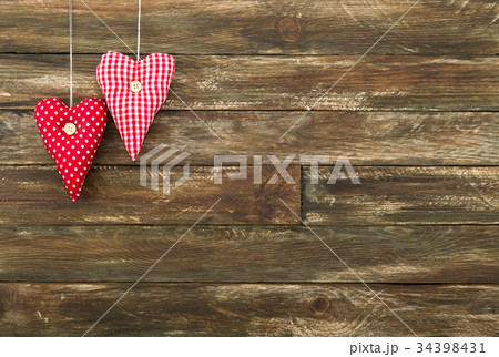 Red Hearts Hanging over Brown Wooden Background 34398431
