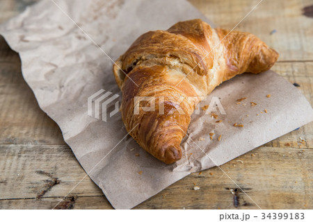 Fresh croissant lies on paper 34399183