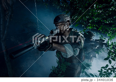 Special Forces soldiers in action. Elite squad moves through fog and smoke. 34401036