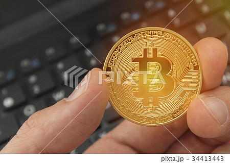 Holding a bitcoin digital currency with laptop Holding a bitcoin digital currency with laptop 34413443