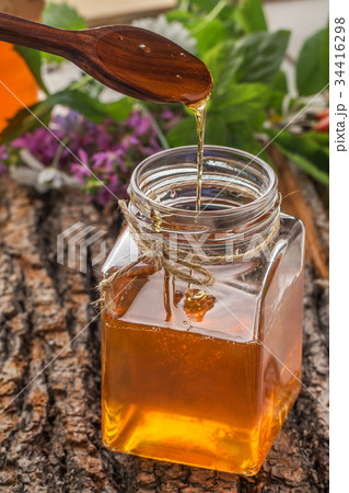 Honey bowl with dipper and flowing honey Honey bowl with dipper and flowing honey 34416298