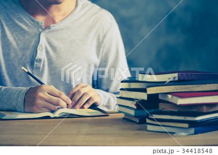 a man writing in notebook, Stack of old books a man writing in notebook, Stack of old books 34418548