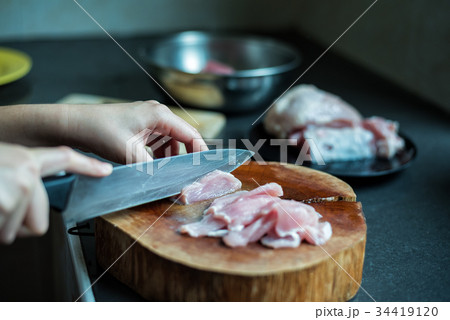 female cook cutting pork on kitchen female cook cutting pork on kitchen 34419120