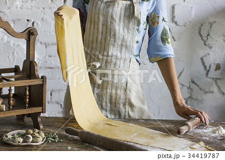 Young woman in apron holding dough  Young woman in apron holding dough  34419787