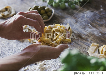 young man preparing homemade pasta on table young man preparing homemade pasta on table 34419851