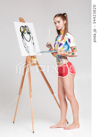 woman painter soiled in colorful paint draws on 34423620