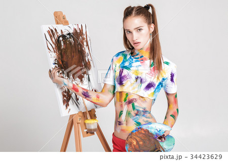woman painter soiled in colorful paint draws on 34423629