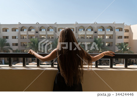 The girl is standing on the balcony at the hotel The girl is standing on the balcony at the hotel 34424446