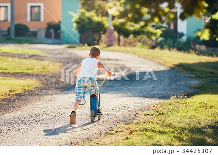 Boy with push scooter 34425307