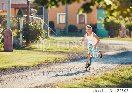 Boy with push scooter 34425308
