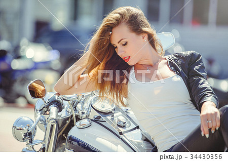 Casual beautiful woman sits on a big tourist motor 34430356