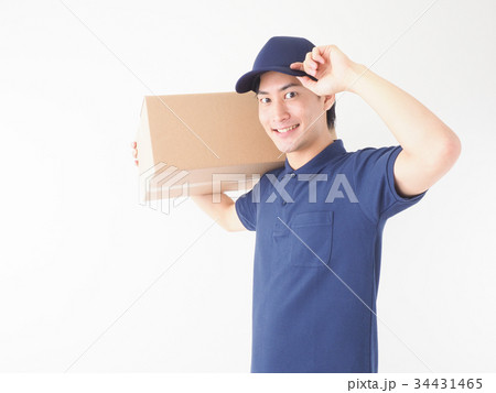 ダンボール箱を担いで帽子に手をやる作業員 34431465