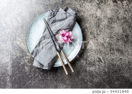 Chopsticks and sakura flowers on gray plate, stone Chopsticks and sakura flowers on gray plate, stone 34431949