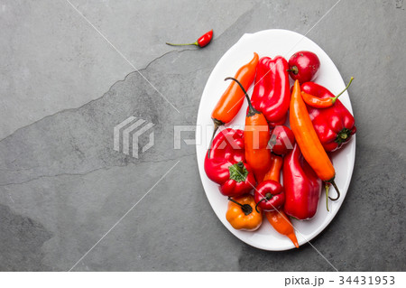 Chili and bell pepper on white plate, slate Chili and bell pepper on white plate, slate 34431953