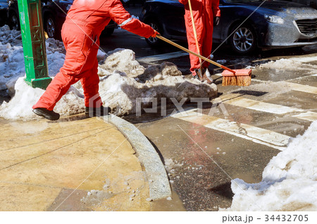 Janitor cleans the street of snow in the morning 34432705